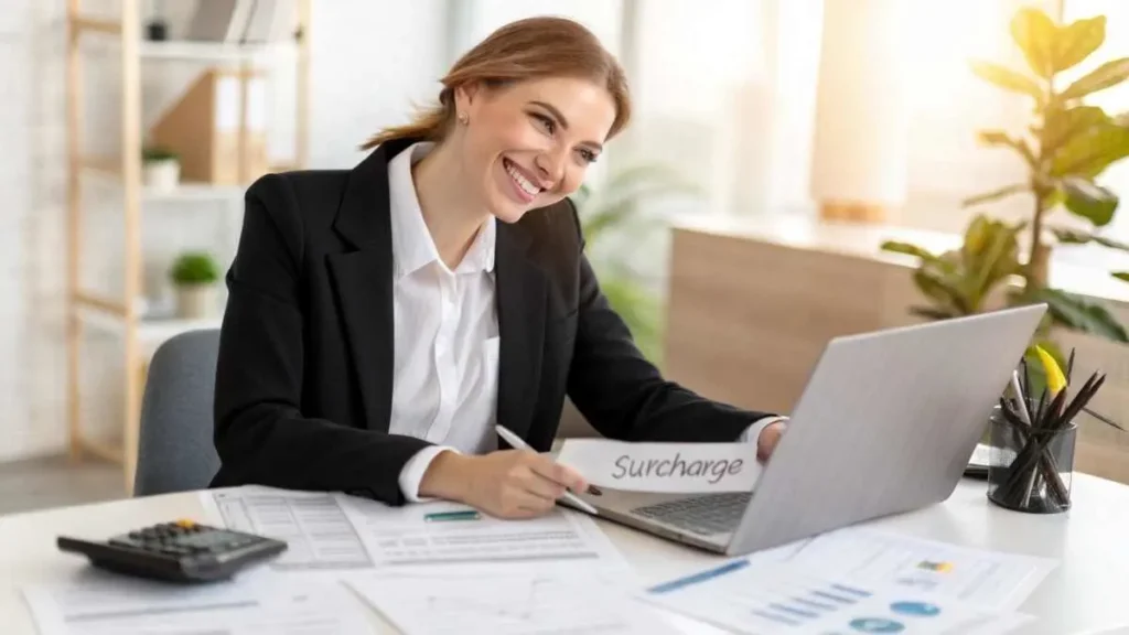 Professional young woman accountant working on credit card surcharge accounting in a modern office, reviewing financial reports and laptop